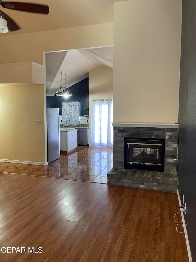 unfurnished living room featuring lofted ceiling, dark wood-type flooring, and sink