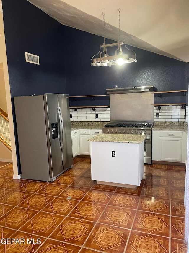 kitchen with decorative backsplash, a kitchen island, appliances with stainless steel finishes, white cabinetry, and pendant lighting