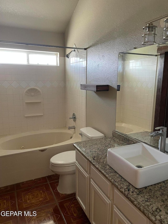 full bathroom featuring toilet, tiled shower / bath combo, vanity, and tile patterned flooring