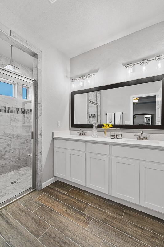 bathroom featuring a tile shower, vanity, and a textured ceiling