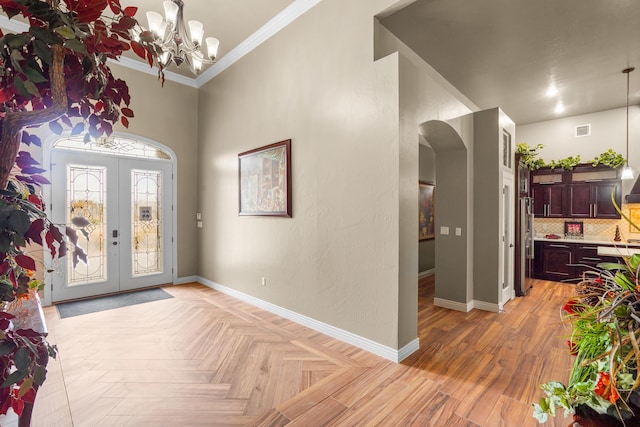 2425 Cesar Cordova Pl, El Paso, TX 79938 - foyer with light parquet floors, crown molding, french doors, and an inviting chandelier
