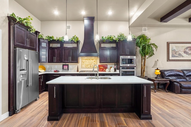 2425 Cesar Cordova Pl, El Paso, TX 79938 - kitchen with an island with sink, pendant lighting, premium range hood, appliances with stainless steel finishes, and sink