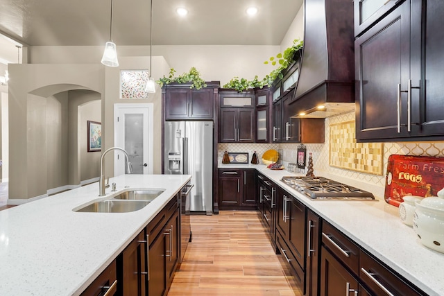 2425 Cesar Cordova Pl, El Paso, TX 79938 - kitchen featuring tasteful backsplash, light hardwood / wood-style floors, custom range hood, sink, and hanging light fixtures