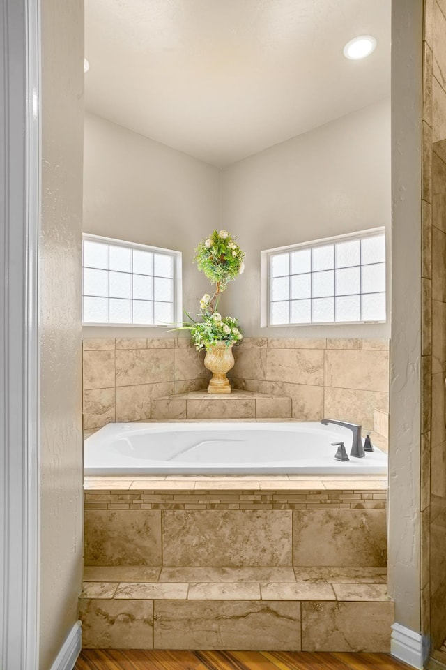 2425 Cesar Cordova Pl, El Paso, TX 79938 - bathroom featuring hardwood / wood-style floors and tiled tub