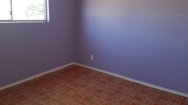 spare room featuring dark parquet floors