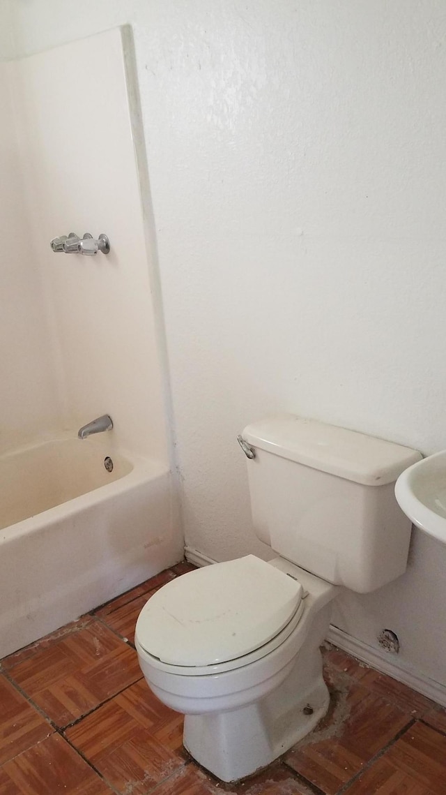 bathroom featuring parquet floors and toilet