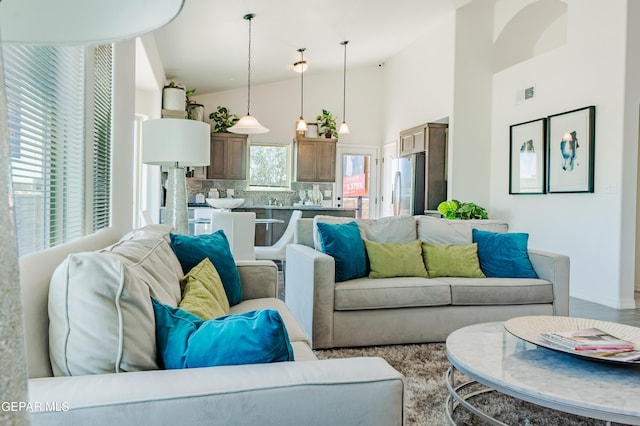 living area featuring visible vents and high vaulted ceiling