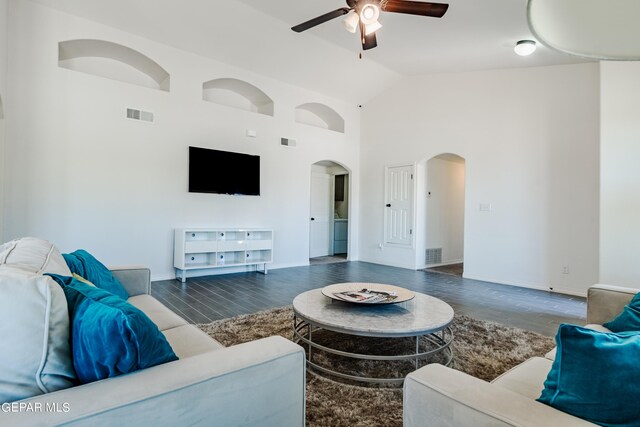 living room featuring ceiling fan, dark hardwood / wood-style floors, and high vaulted ceiling