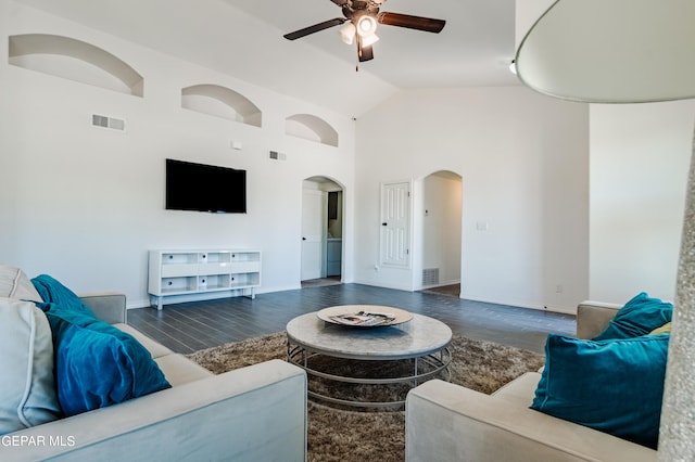 living room featuring wood finished floors, a ceiling fan, arched walkways, and visible vents