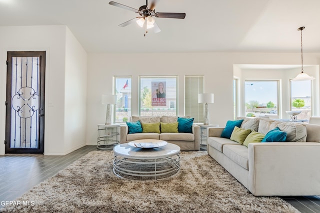 living room featuring ceiling fan, baseboards, and wood finished floors