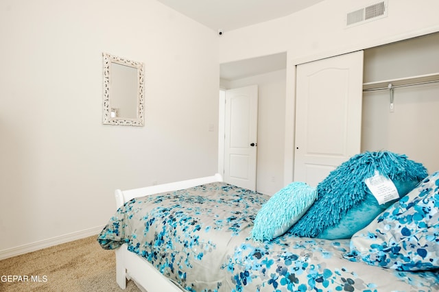 bedroom with baseboards, visible vents, a closet, and carpet floors