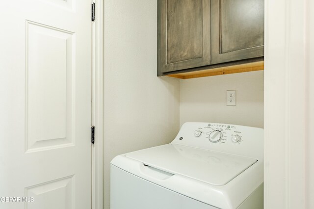 washroom with cabinets and washer / clothes dryer