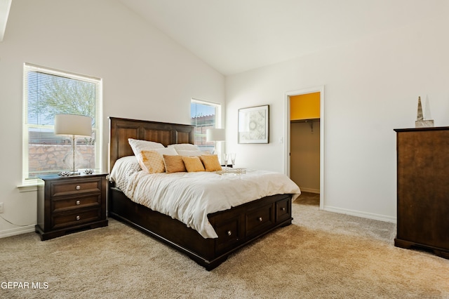 bedroom featuring a spacious closet, baseboards, light colored carpet, a closet, and high vaulted ceiling