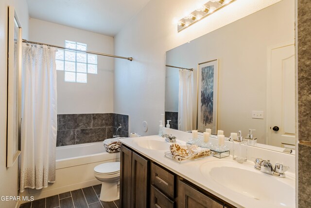 full bathroom featuring shower / bath combo with shower curtain, hardwood / wood-style flooring, vanity, and toilet