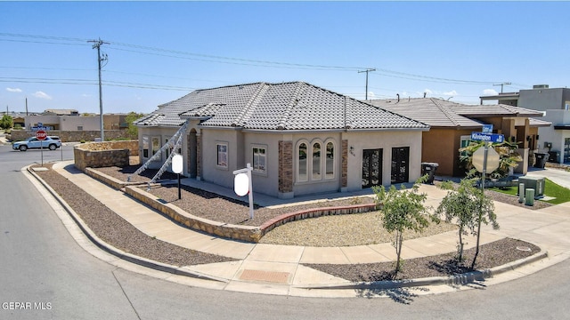 view of front of house with a tile roof and stucco siding
