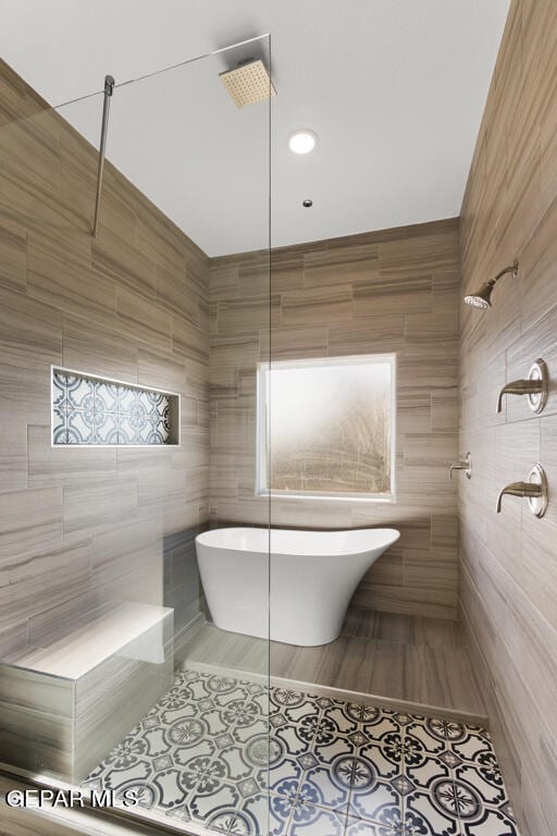 bathroom featuring a tile shower, tile flooring, and tile walls