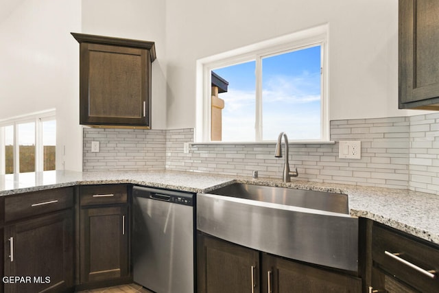 kitchen featuring sink, dark brown cabinets, dishwasher, light stone countertops, and tasteful backsplash