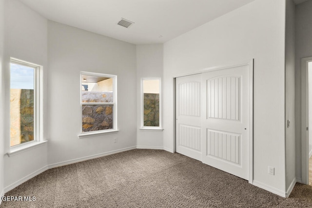 unfurnished bedroom featuring a closet and dark colored carpet