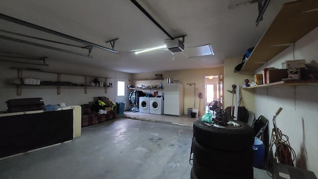 garage with a garage door opener, white refrigerator, and independent washer and dryer