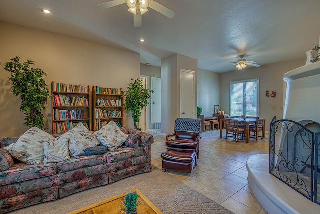 living room featuring light tile floors and ceiling fan