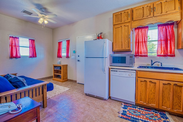 kitchen featuring light tile floors, ceiling fan, and white appliances