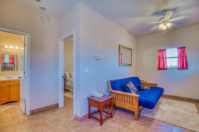 living area featuring light tile flooring, ceiling fan, a textured ceiling, and sink