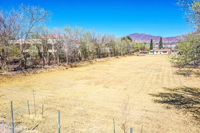 view of yard with a mountain view and fence