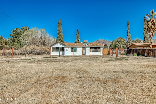 back of property featuring a yard and fence