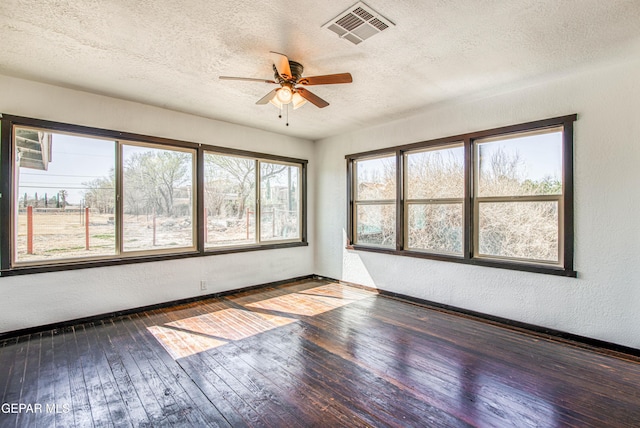 unfurnished sunroom with visible vents and ceiling fan