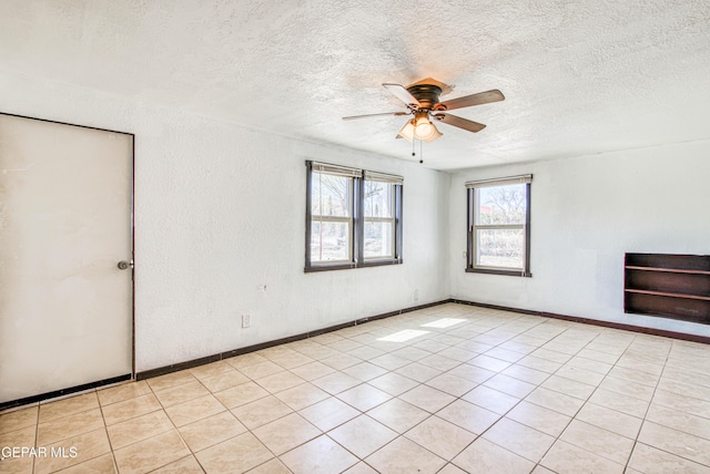 unfurnished room featuring baseboards, a textured ceiling, a ceiling fan, and a textured wall