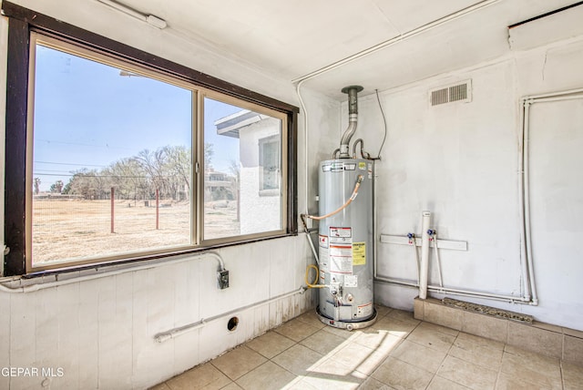 utility room featuring visible vents and water heater