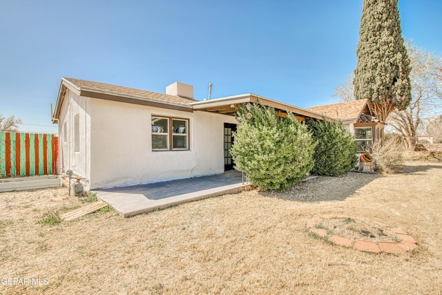 rear view of property featuring a patio and stucco siding