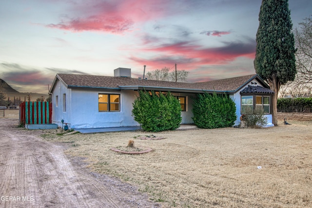 view of front of home with a shingled roof and stucco siding