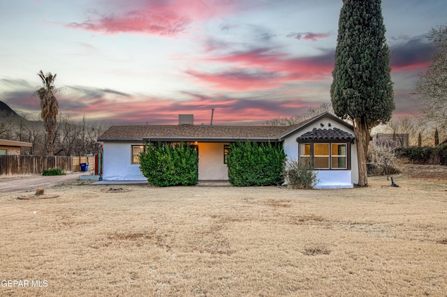 view of front of property featuring fence and stucco siding