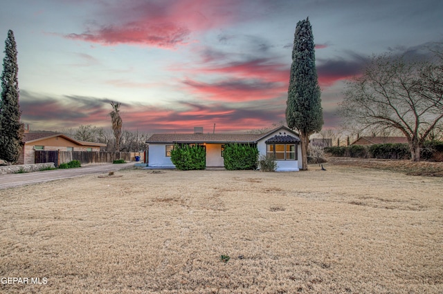 view of front facade with a front yard and fence