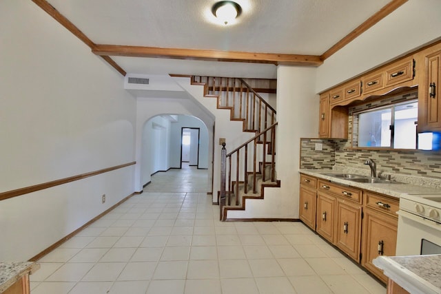 kitchen featuring light tile floors, tasteful backsplash, and beamed ceiling