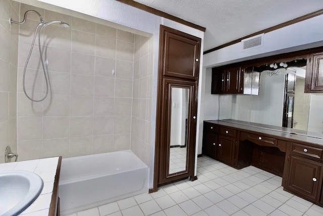 bathroom featuring tile flooring, a textured ceiling, oversized vanity, and tiled shower / bath