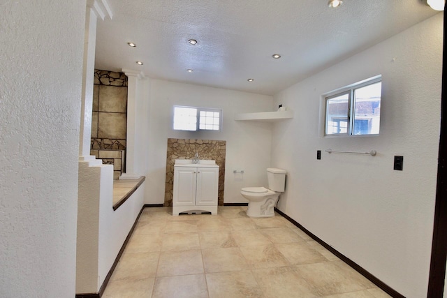 bathroom with toilet, tile flooring, and a textured ceiling