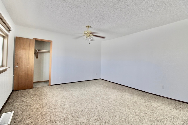 unfurnished bedroom featuring carpet floors, a closet, ceiling fan, and a textured ceiling