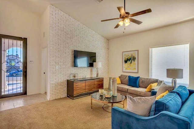 carpeted living room with lofted ceiling, brick wall, ceiling fan, and a healthy amount of sunlight