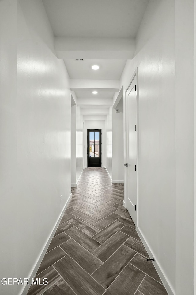 hallway with parquet floors, visible vents, baseboards, and recessed lighting