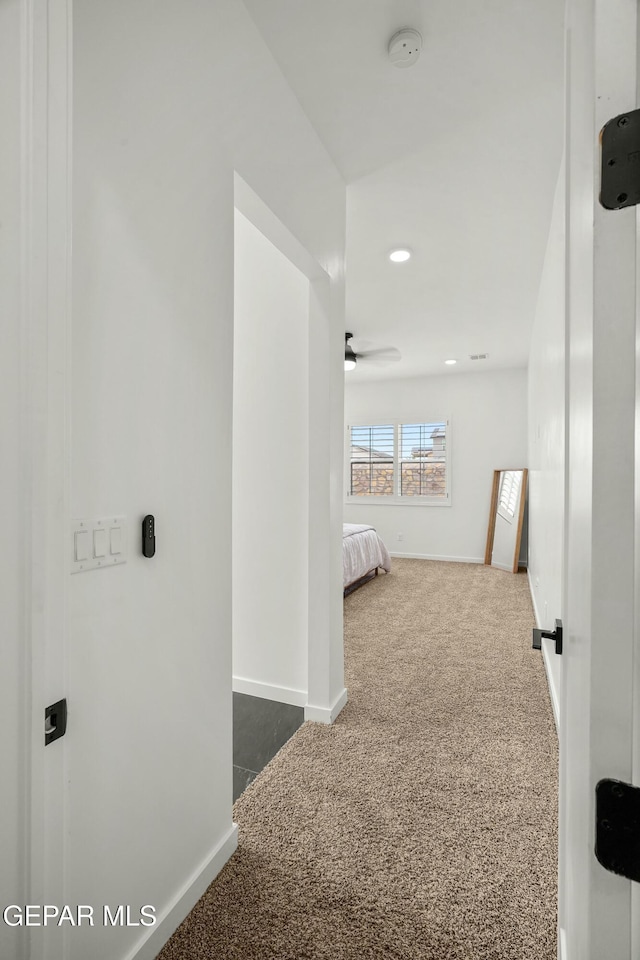 corridor with dark colored carpet, recessed lighting, and baseboards