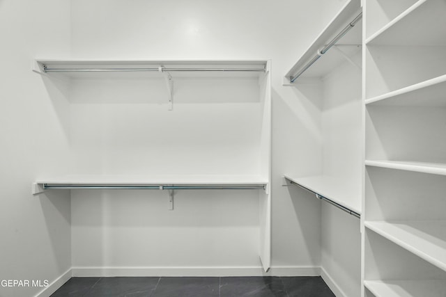 walk in closet featuring dark tile patterned floors