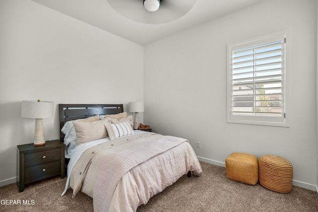 carpeted bedroom with ceiling fan and baseboards