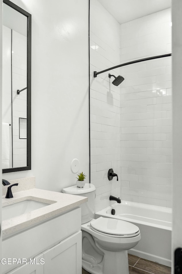 bathroom with toilet, bathing tub / shower combination, vanity, and wood finished floors