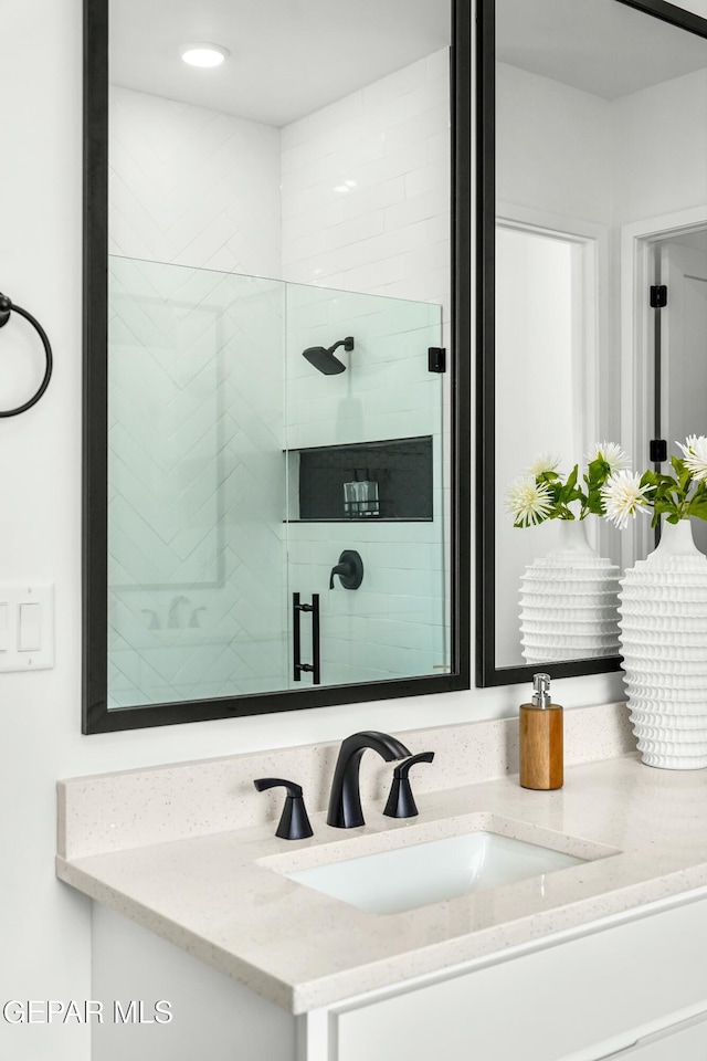 bathroom featuring a shower stall and vanity