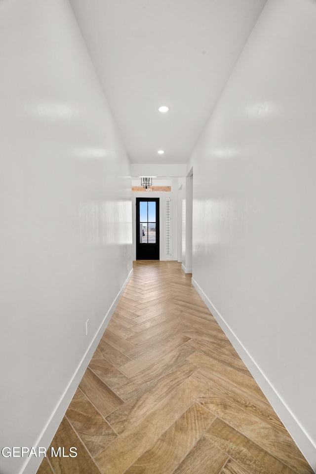 hallway with recessed lighting and baseboards