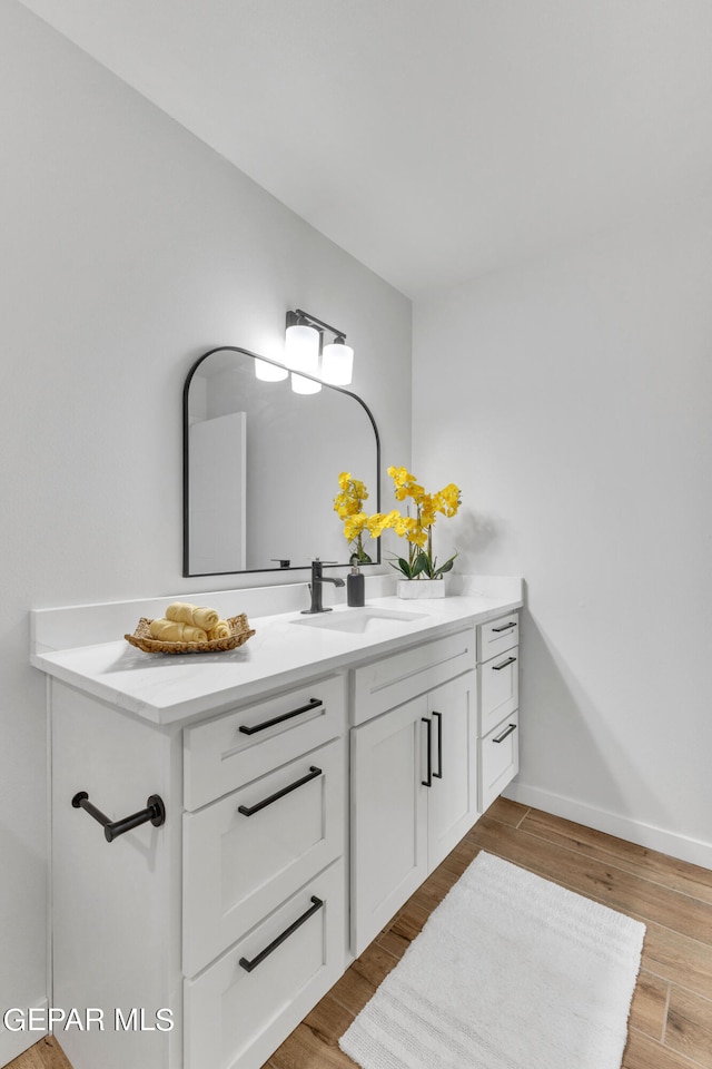 bathroom with oversized vanity and hardwood / wood-style flooring