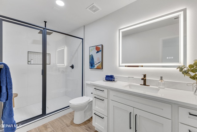 bathroom with walk in shower, toilet, vanity, and wood-type flooring