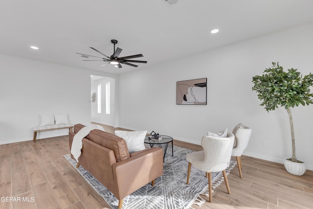 living room featuring ceiling fan and light hardwood / wood-style flooring